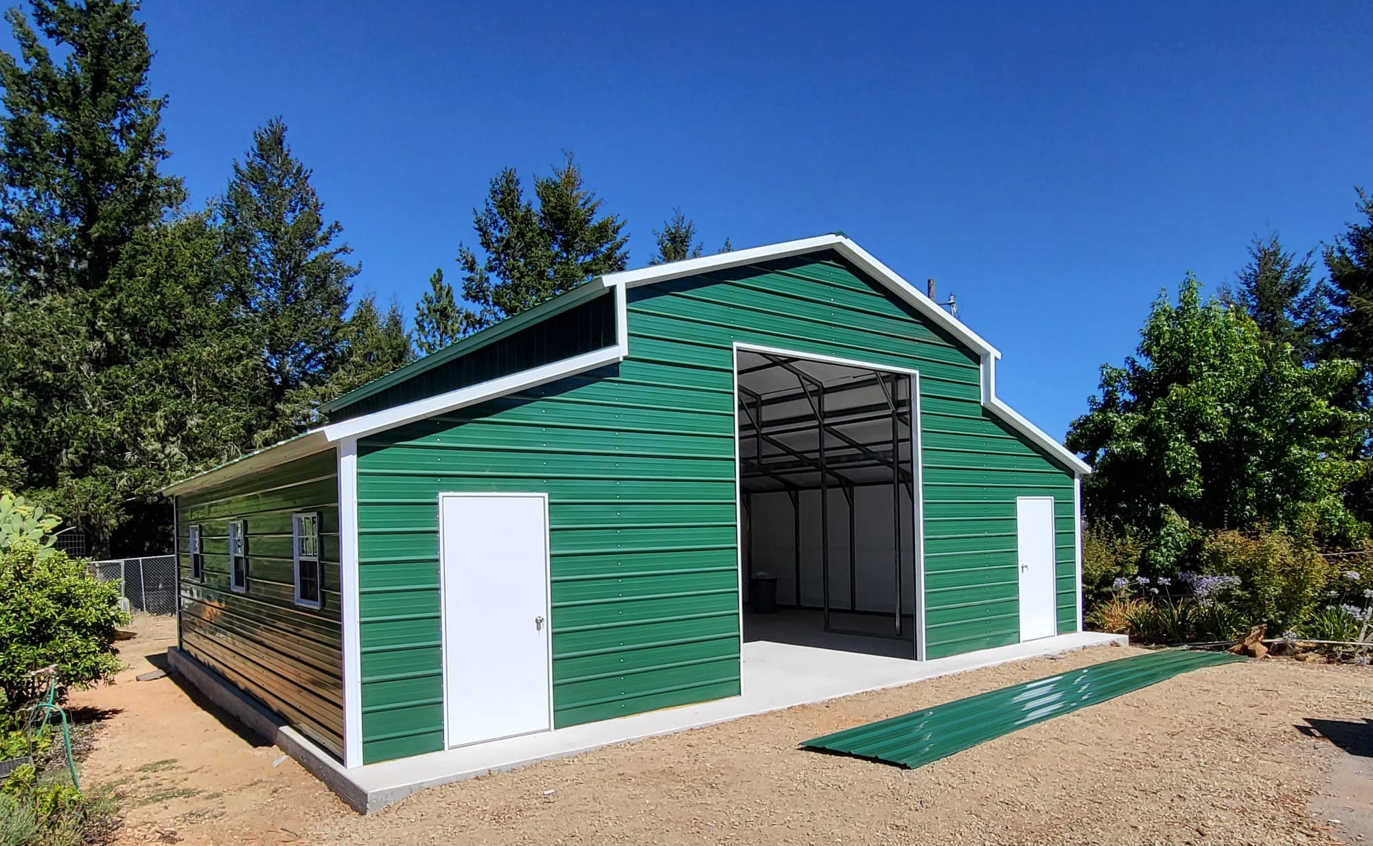 Raised-center-aisle steel barn with lean-to sheds on both sides