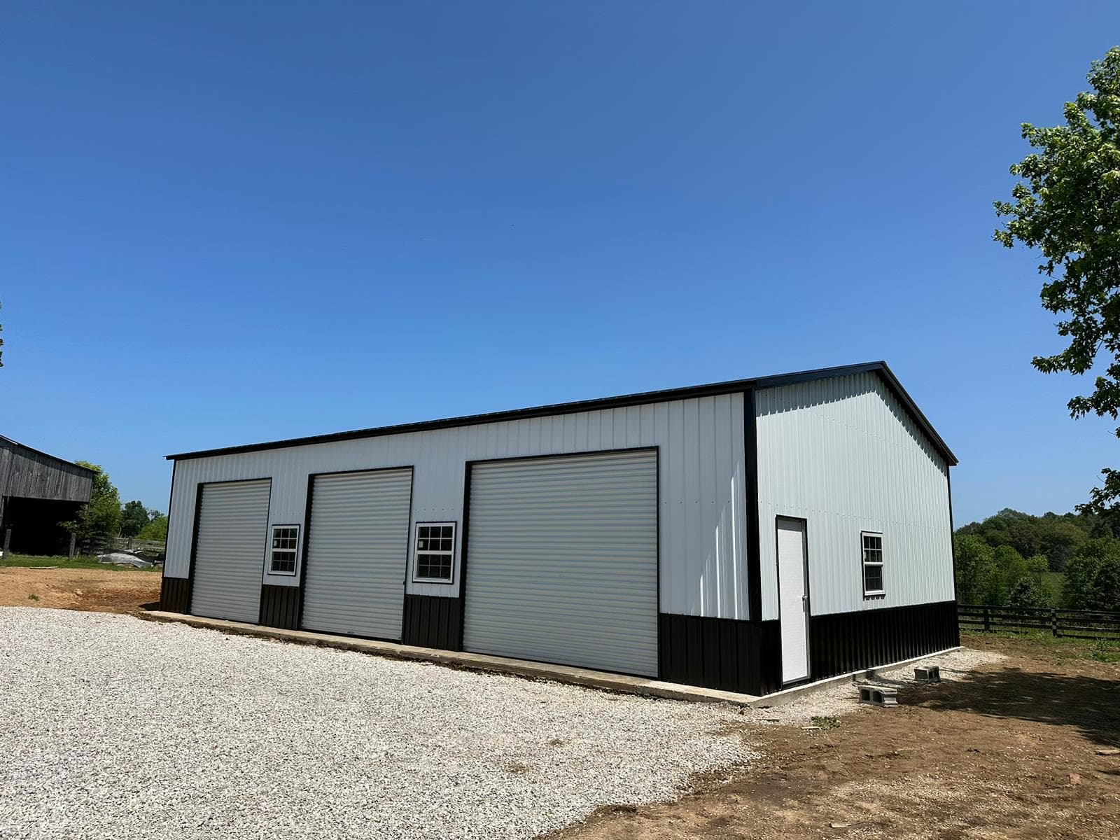 Two-car enclosed metal garage with two roll-up doors